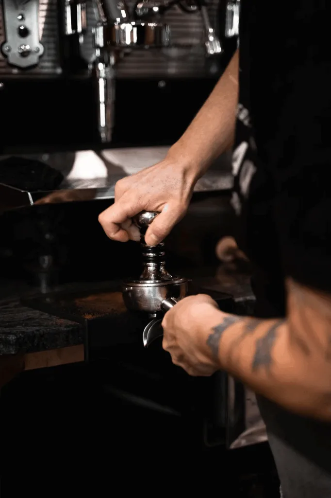 barista hands operating espresso machine with perfect shot extraction
